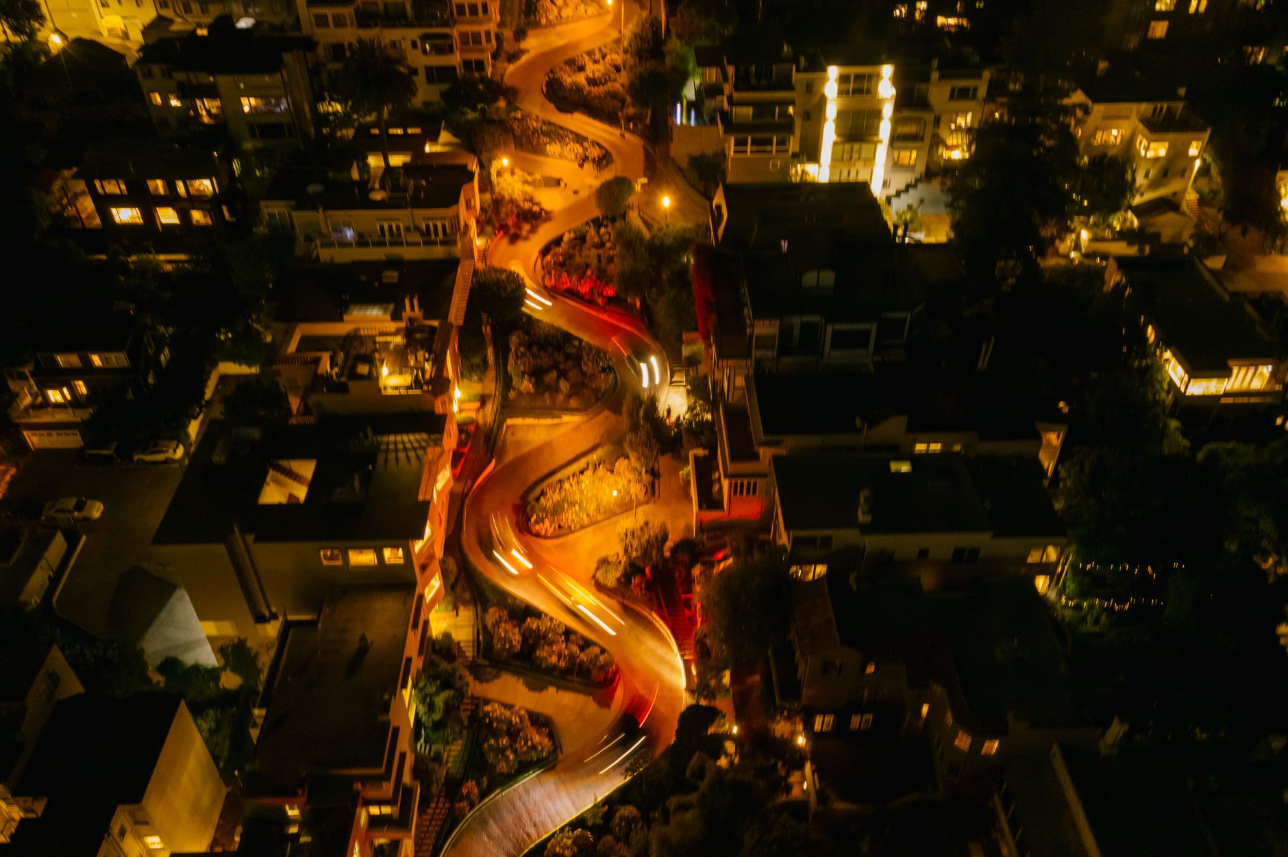 Stunning aerial view of the winding Lombard Street in San Francisco at night, illuminated by streetlights.